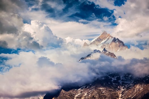 Snowcapped summit top of mountain in Himalayas in clouds. Sangla, Himachal Pradesh, India