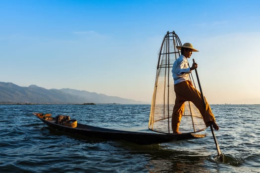 Myanmar travel attraction landmark - Traditional Burmese fisherman at Inle lake, Myanmar famous for their distinctive one legged rowing style