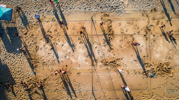 An artistic aerial shot captures people strolling on a beach, casting electric blue shadows on the sandy slope, creating a stunning pattern resembling terrestrial animal prints AIG50