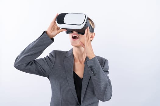 Skilled businesswoman looking at visual reality world by using VR glass while standing at background. Smart manager holding VR goggle to connect metaverse by using technology innovation. Contraption.