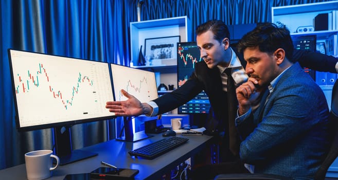 Stock exchange traders looking on high profit chart investment in panorama view, analyzing on monitor at night. Concept of discussing financial technology growth in neon light at workplace. Sellable.