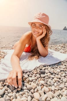 Happy smiling young woman sunbathing or tanning on a seaside beach during summer vacation. Slow motion of happy tourist in red swimsuit enjoying sun tan lying on beach chair lounge at luxury resort.