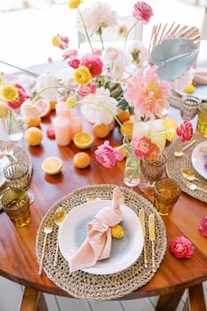 Knotted napkin on a plate on a wicker mat next to cutlery stands on a festive table. High quality photo