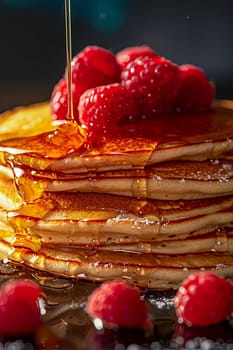 Pancakes with fresh raspberries and honey close-up, delicious and healthy summer food.