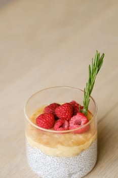 Delicious passion fruit and banana smoothie with raspberries in a glass.