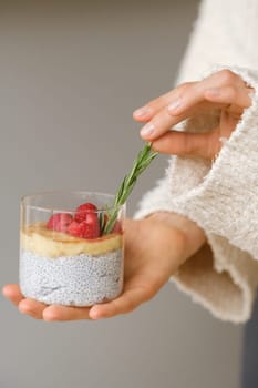 Delicious passion fruit and banana smoothie with raspberries in a glass on your hand.