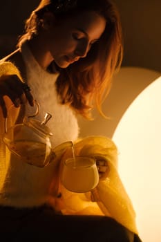 A young girl conducts an evening tea drinking procedure indoors. Relaxing tea party.