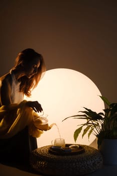 A young girl conducts an evening tea drinking procedure indoors. Relaxing tea party.