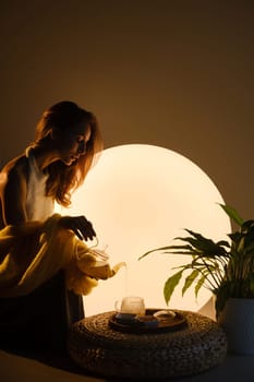 A young girl conducts an evening tea drinking procedure indoors. Relaxing tea party.