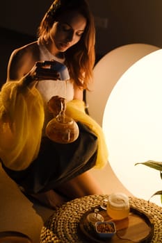 A young girl conducts an evening tea drinking procedure indoors. Relaxing tea party.