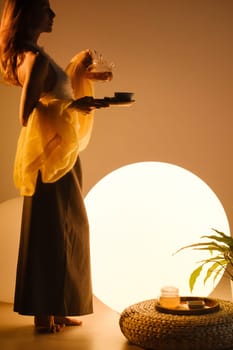 A young girl conducts an evening tea drinking procedure indoors. Relaxing tea party.