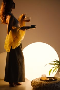 A young girl conducts an evening tea drinking procedure indoors. Relaxing tea party.