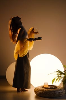 A young girl conducts an evening tea drinking procedure indoors. Relaxing tea party.