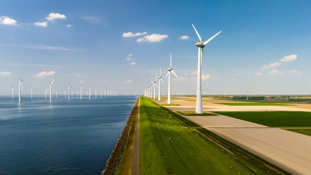 A line of majestic wind turbines stand tall next to a tranquil body of water, harnessing the power of the wind to generate energy for the surrounding area.