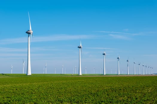 A vast field of lush green grass stretches as far as the eye can see, dotted with towering windmills in the background, their blades spinning gracefully in the breeze. windmill turbines on land