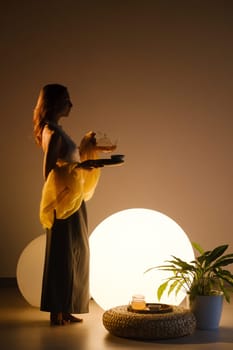 A young girl conducts an evening tea drinking procedure indoors. Relaxing tea party.