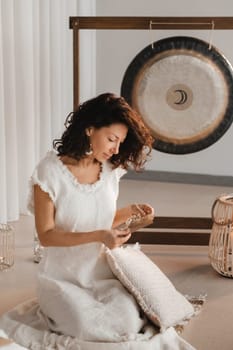 A woman in white clothes holds an envelope with a wish in her hands. The concept of a women's circle.