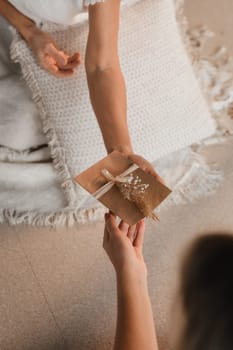 A woman in white clothes passes an envelope with a wish to another woman. The concept of the women's circle.