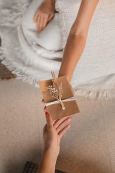 A woman in white clothes passes an envelope with a wish to another woman. The concept of the women's circle.