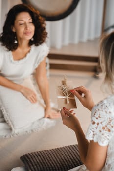 A woman in white clothes holds an envelope with a wish in her hands. The concept of a women's circle.