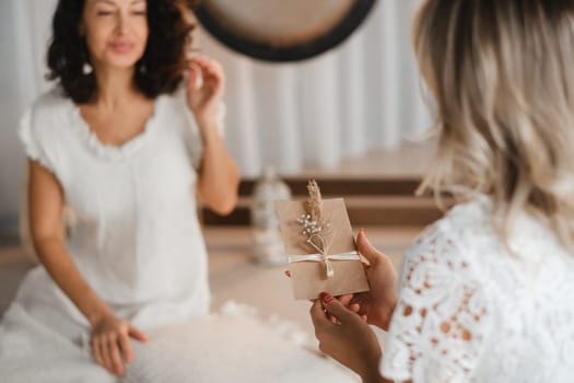 A woman in white clothes holds an envelope with a wish in her hands. The concept of a women's circle.