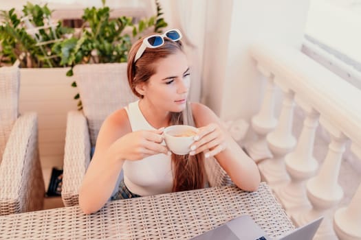 Woman coffee cafe macbook. Woman sitting at a coffee shop with mobile phone drinking coffee and looking away. Caucasian female relaxing at a cafe