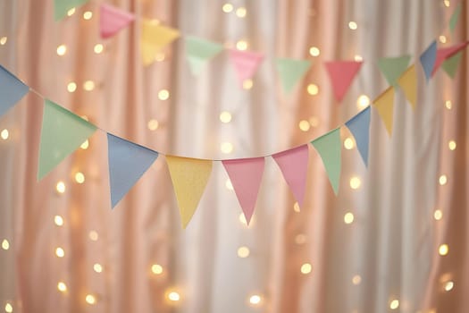 The room is decorated with garlands of multi-colored triangles and light bulbs. The concept of organizing a holiday.