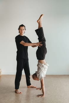 two young athletes practice yoga in the gym. Joint training, indoors, studio. The concept of a healthy lifestyle.