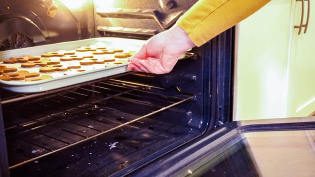 Scrumptious gingerbread cookies getting baked to perfection in a gas oven, filling the kitchen with warm, aromatic holiday bliss.