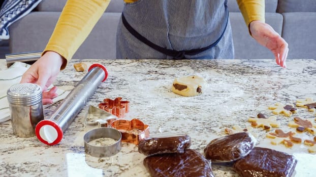 Using an adjustable rolling pin to roll out gingerbread cookie dough on the elegant marble counter in a modern kitchen, getting ready for festive holiday baking.