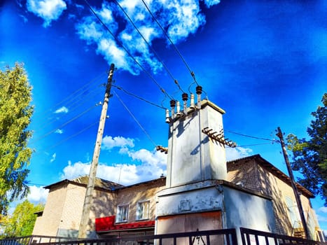 Sunlit Electrical Transformer on Clear Day. Sunny day showcasing a transformer with power lines against a blue sky