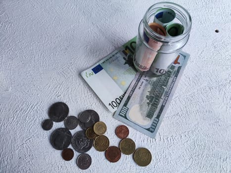 Glass Jar Filled With Euro Banknotes and Coins on Table. The concept of savings ranging from small money to large