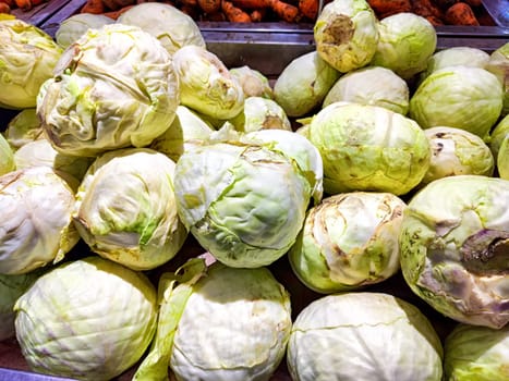 A vibrant selection of cabbages arranged for sale. Fresh Green Cabbages on Display at a Local Market Stall