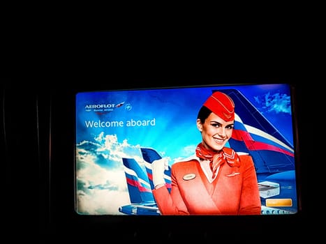 Moscow, Russia - April 04, 2024: Aeroflot flight attendant on the TV screen on plane. Aeroflot Welcome Aboard Message Displayed on In-flight Screen