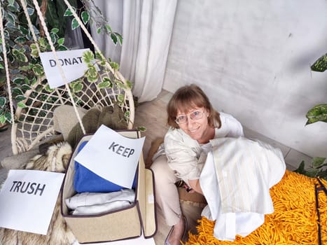 Middle-Aged Woman Sorting Belongings With KonMari Method. Mature woman categorizes items into keep and discard piles