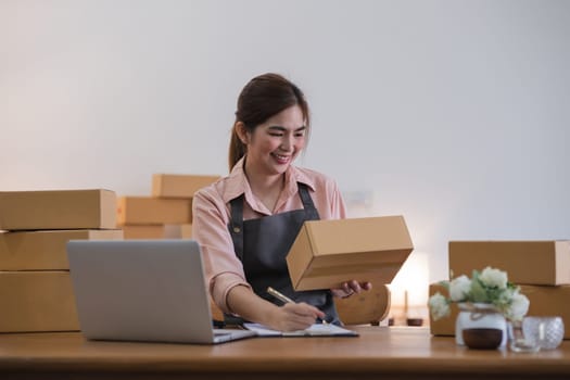 Business From Home Asian woman preparing package delivery box Shipping for shopping online. young start up small business owner at home online order.