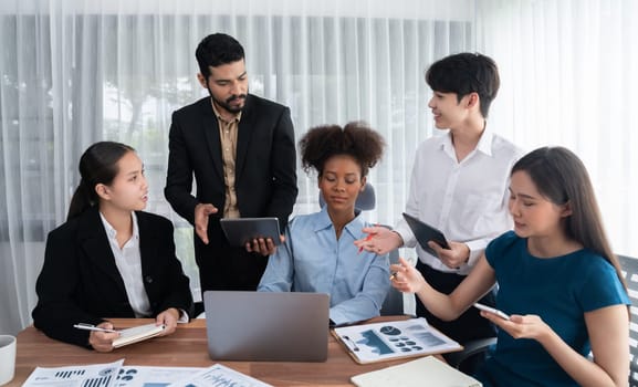 Happy diverse business people work together, discussing in corporate office. Professional and diversity teamwork discuss business plan on desk with laptop. Modern multicultural office worker. Concord