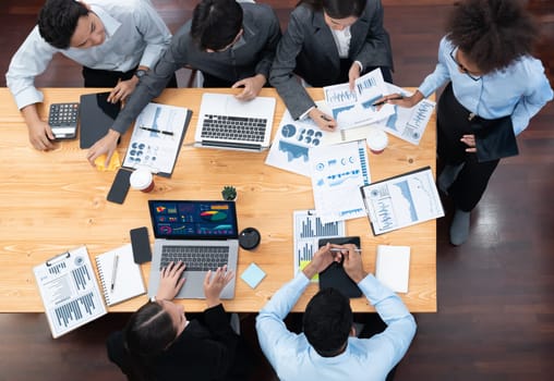 Top view multiracial analyst team use BI dashboard display on laptop screen, analyzing financial data for strategic decision. Fintech analyzes marketing indicators. Concord