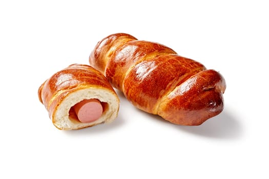 Appetizing freshly baked sausage rolls of frankfurters wrapped in yeast pastry, isolated on white background. Popular baked savory snack