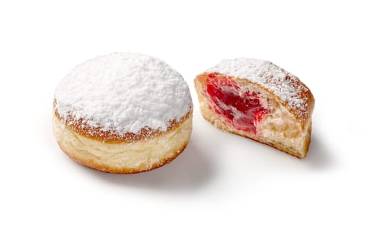 Whole and halved jelly doughnuts with soft airy texture and sweet raspberry filling, dusted with powdered sugar, on white backdrop