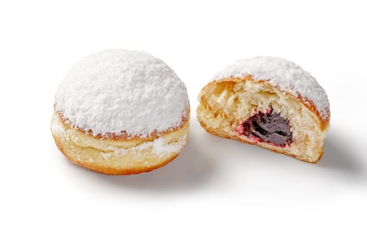 Delicious sweet soft doughnuts with light currant jam filling, generously dusted with powdered sugar, presented on white background. Popular confectionery with berry flavors