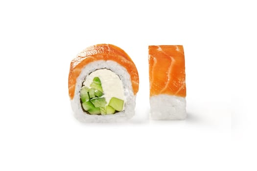 Delicious classic Philadelphia roll filled with cream cheese, cucumbers and avocado topped with slices of raw salmon fillet, isolated on white background