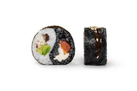 Appetizing sushi roll in shape of yin and yang symbol with black and white rice filled with salmon, eel, avocado and cream cheese topped with unagi sauce and roasted sesame seeds. Japanese cuisine