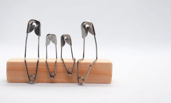 Safety pin represent family sitting on wooden block with customizable space for text.