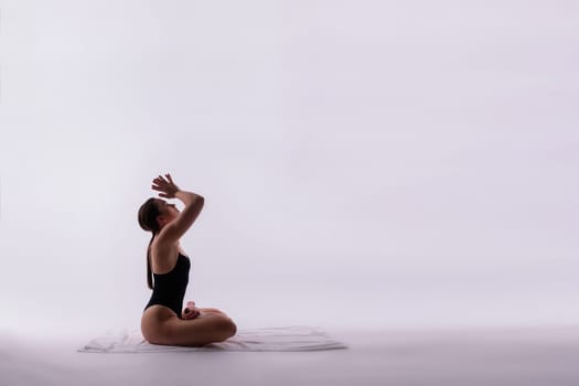 Athletic, beautiful, young girl with sportive strong body training in bodysuit against orange studio background. Flexibility. Concept of sport, healthy and active lifestyle, beauty, fitness.