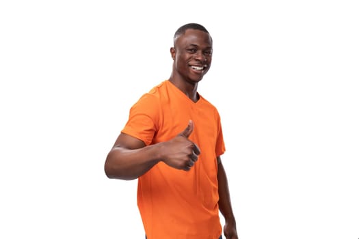 young positive happy american man in orange t-shirt with mock up isolated on white background.