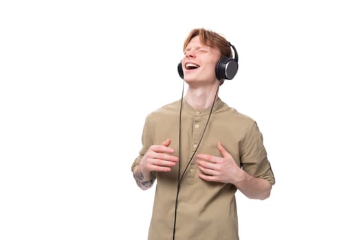 young handsome redhead man in glasses and shirt enjoying playlist in headphones.