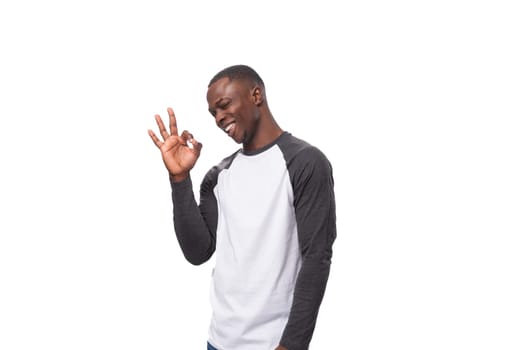young charismatic african man dressed casual smiling on white background with copy space.