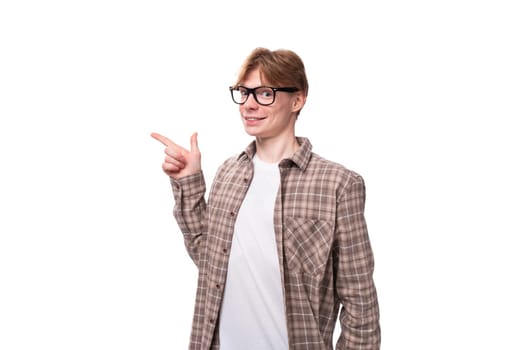 close-up portrait of a young dreaming caucasian man with red short hair pointing his finger to the side.