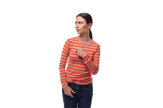 young adult woman dressed in an orange striped jacket looks away with surprise.